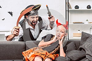 portrait of daughter and father in halloween costumes playing