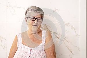 Portrait of a dear old woman wearing glasses, smiling, looking to the side, on a hot summer day. Retirement, free life