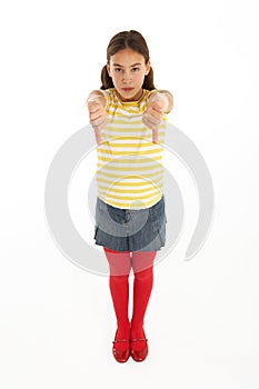 Portrait Of Defiant Young Girl Giving Thumbs Down photo