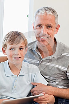 Portrait of a delighted father and his son using a tablet