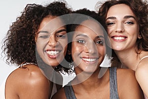 Portrait of delighted multiracial women standing together and smiling