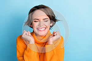 Portrait of delighted positive girl closed eyes raise fists luck accomplishment isolated on blue color background