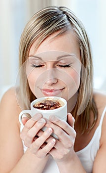 Portrait of a delighted woman drinking a coffee