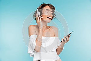 Portrait of a delighted young woman listening to music