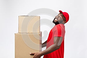 Portrait of delivery african american man in red shirt. he lifting heavy weight boxes against having a isolated on the