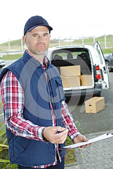 Portrait delivery man holding clipboard