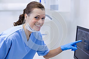 Portrait of dental assistant examining an x-ray on the monitor