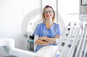 A portrait of dental assistant in modern dental surgery, looking at camera.