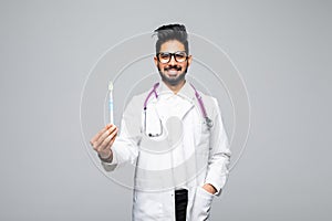 Portrait of a dentist holding a toothbrush, isolated on white background with copy space