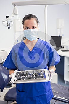 Portrait of a dentist with surgical mask and holding tray