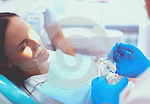 Portrait of a dentist who treats teeth of young woman patient