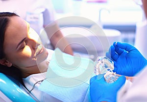 Portrait of a dentist who treats teeth of young woman patient