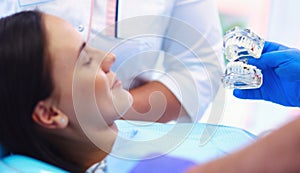 Portrait of a dentist who treats teeth of young woman patient