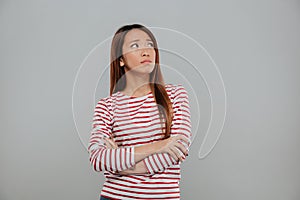 Portrait of a depressed asian woman standing with arms folded