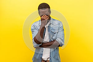 Portrait of depressed hopeless man hiding face and crying. studio shot isolated on yellow background