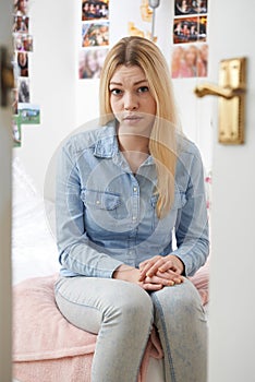 Portrait Of Depressed Teenage Girl In Bedroom