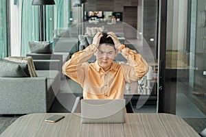 Portrait of depressed young business Asian, Chinese man person thinking about problems and suffering from depression with laptop