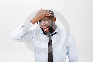 Portrait of desperate annoyed black male screaming in rage and anger tearing his hair out while feeling furious and mad