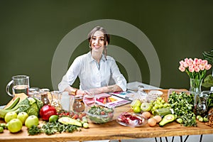 Portrait of the dietitian with healthy food in the office