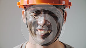 Portrait Dirty Mine Worker. Beautiful Caucasian Man in a Hard Hat Smiles. Filthy Job and Physical labor. People Working Equipment