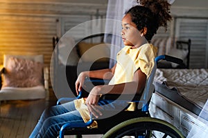 Portrait of disabled black girl with wheelchair at home