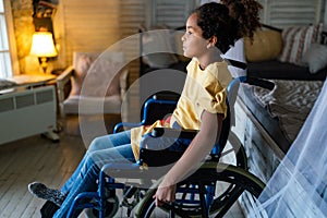 Portrait of disabled black girl with wheelchair at home