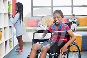 Portrait of disabled schoolboy on wheelchair in library