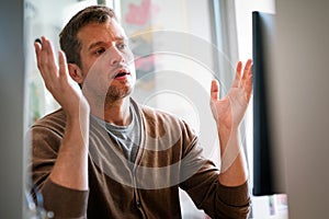 Portrait of a disappointed man programmer looking stressed out while working on a computer code