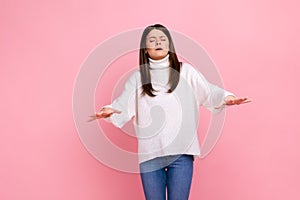 Portrait of disoriented young woman walking with eyes closed and holding out her hands to find road.