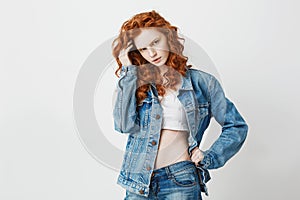 Portrait of displeased cool foxy girl in jean jacket over white background. Copy space.