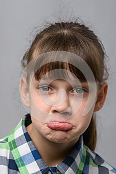 Portrait of a displeased ten-year-old girl of European appearance, close-up