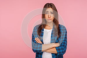 Portrait of displeased unhappy brunette girl in bad mood looking at camera with resentful vexed face