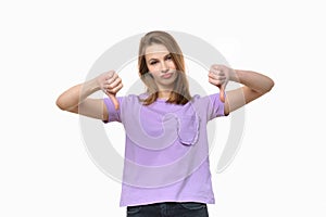 Portrait of displeased young woman showing thumbs down gesture on white background