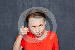 Portrait of dissatisfied girl pointing with index finger at you