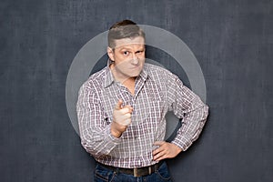 Portrait of dissatisfied man pointing with forefingers at you