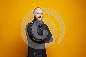 Portrait of diver man with crossed arms on yellow background