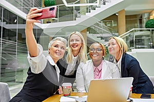 Portrait of diverse business women taking selfie on smartphone