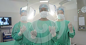 Portrait of diverse female surgeons wearing surgical gowns in operating theatre, slow motion