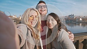 Portrait of diverse friends enjoying their mood. Attractive man, asian girl, and natural blonde young woman smiling at