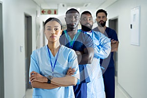 Portrait of diverse group of healthcare workers standing in line in hospital corridor