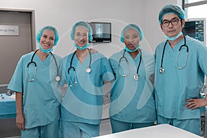 Portrait of diverse group of male and female doctors standing in operating theatre