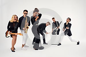 Portrait of diverse group of young people musical band playing with instruments - isolated on white background.