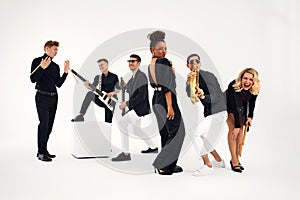 Portrait of diverse group of young people musical band playing with instruments - isolated on white background.