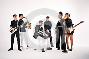 Portrait of diverse group of young people musical band playing with instruments - isolated on white background.