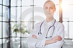 Confident female doctor posing in her office