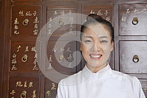 Portrait of Doctor In Front of Traditional Chinese Medicine Cabinet