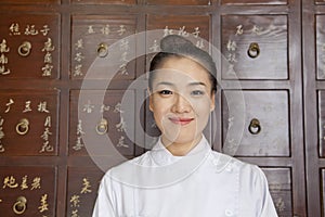 Portrait of Doctor In Front of Traditional Chinese Medicine Cabinet