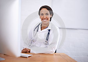 Portrait, doctor and happy woman at desk in hospital for healthcare, wellness or working online on computer. Face, smile