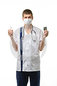 Portrait of a doctor holding a syringe with medicine in one hand and pills in the other hand, isolated on white background