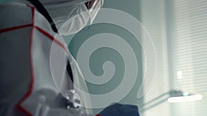 Portrait doctor holding tablet computer in medical protective suit hospital ward